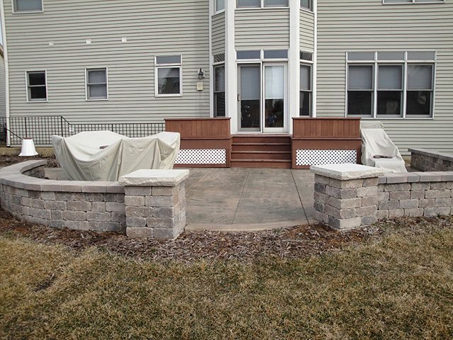 A stamped concrete patio with built-in seat walls, poured by my client.