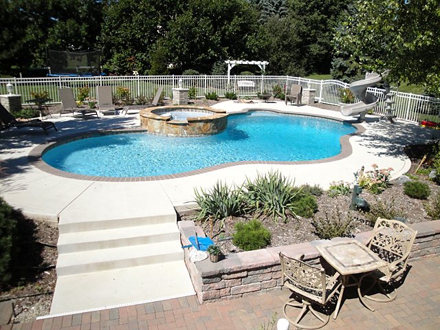 Inground pool surrounded by a stamped concrete pool deck