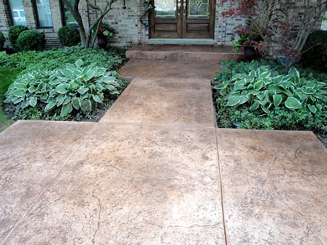 Stamped concrete walkway running between garden beds